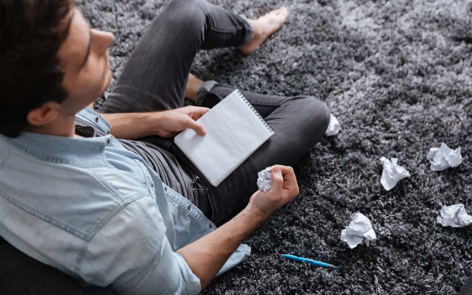 Journalist with a notepad and crumpled drafts, working through an investigation